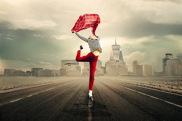Žena tancuje uprostred ulice s červenou šatkou v rukách